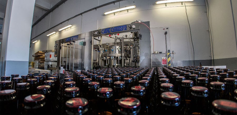 Close-up of a view of bottles at beer packaging machine at Elis Brewery plant
